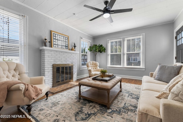 living room with hardwood / wood-style flooring, a fireplace, ornamental molding, and ceiling fan