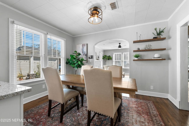 dining room with crown molding, dark wood-type flooring, and ceiling fan