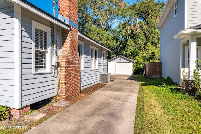 view of side of property with a garage, central AC, a yard, and an outbuilding