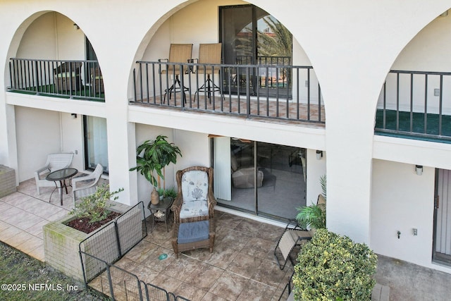 back of property with a balcony and a patio