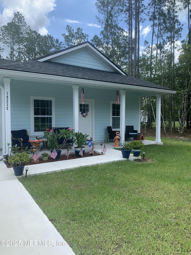 view of front of property featuring covered porch and a front lawn