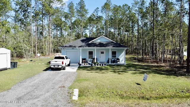 view of front of property featuring a front yard, covered porch, and driveway