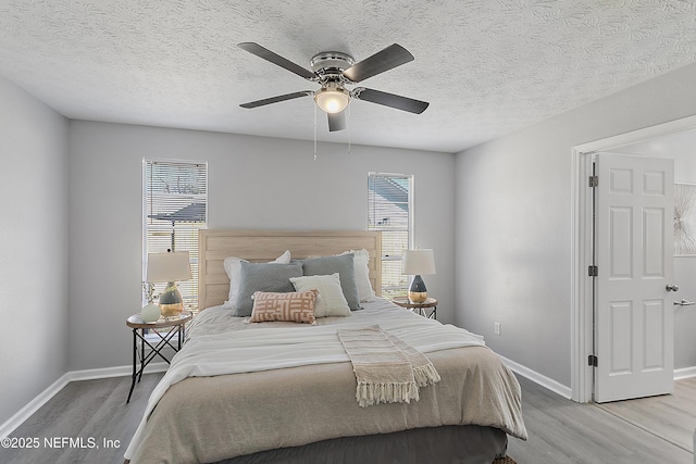 bedroom featuring a textured ceiling, light hardwood / wood-style flooring, and ceiling fan