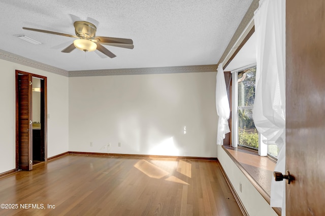 unfurnished room featuring ceiling fan, hardwood / wood-style floors, and a textured ceiling