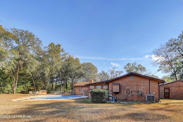 back of property featuring a yard and central air condition unit