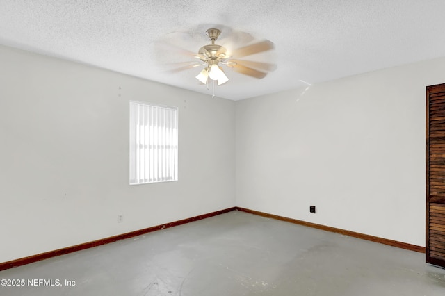 empty room with ceiling fan, concrete floors, and a textured ceiling