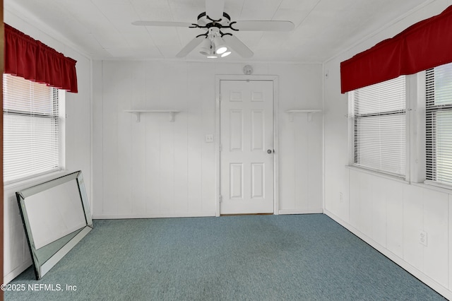 unfurnished room with a wealth of natural light, carpet floors, and ceiling fan