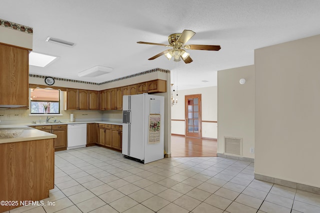 kitchen featuring light tile patterned flooring, sink, ceiling fan, and white appliances