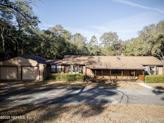 single story home featuring a porch and a garage