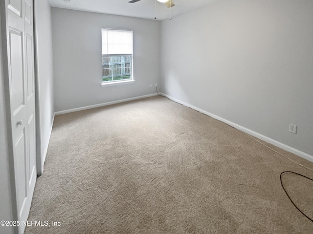 carpeted spare room with ceiling fan