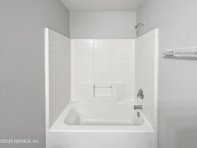 bathroom featuring a textured ceiling and shower / bathing tub combination