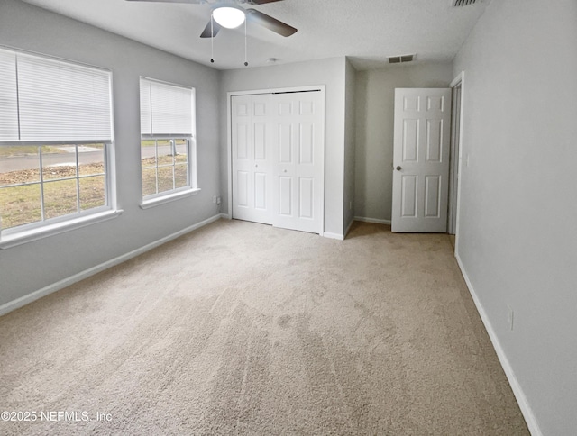 unfurnished bedroom with carpet flooring, ceiling fan, and a closet