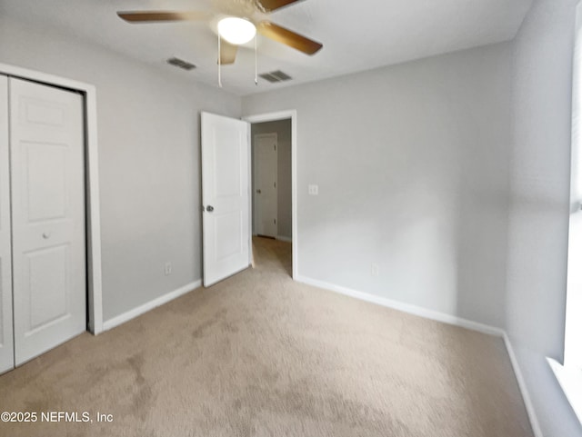 unfurnished bedroom with light colored carpet, a closet, and ceiling fan