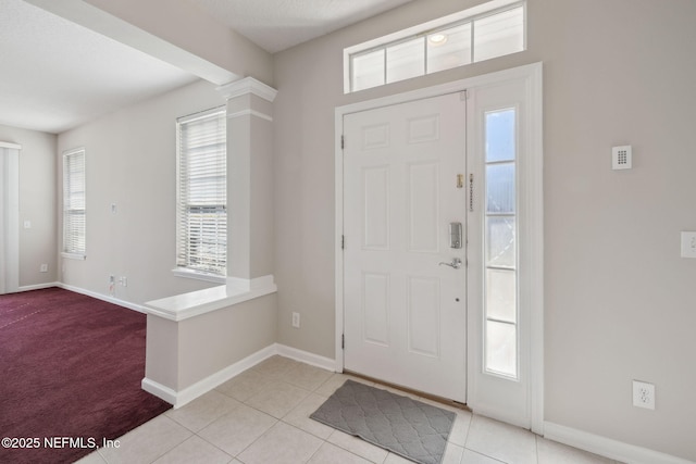 foyer with a wealth of natural light and light tile patterned floors