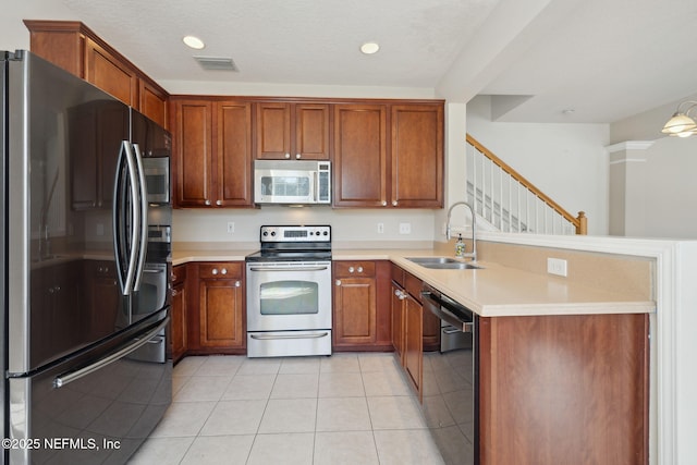 kitchen featuring sink, stainless steel appliances, a textured ceiling, and light tile patterned flooring