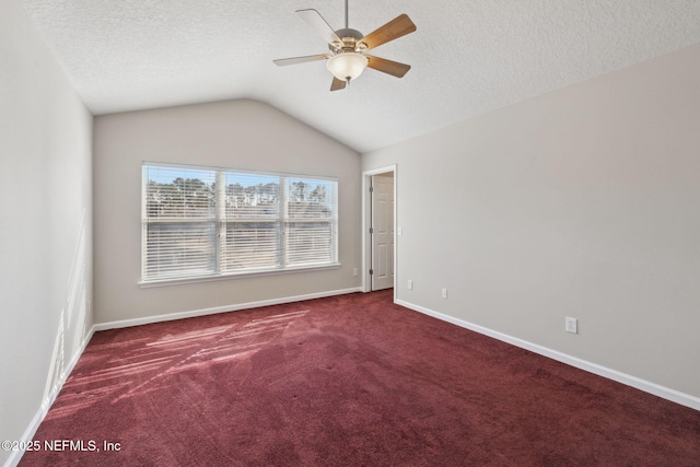 carpeted empty room with ceiling fan, lofted ceiling, and a textured ceiling