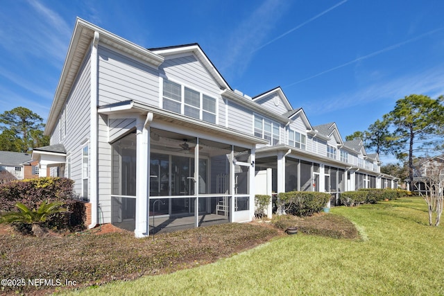 rear view of house featuring a lawn, a sunroom, and ceiling fan