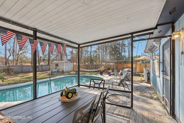 view of swimming pool with a patio area and a storage shed