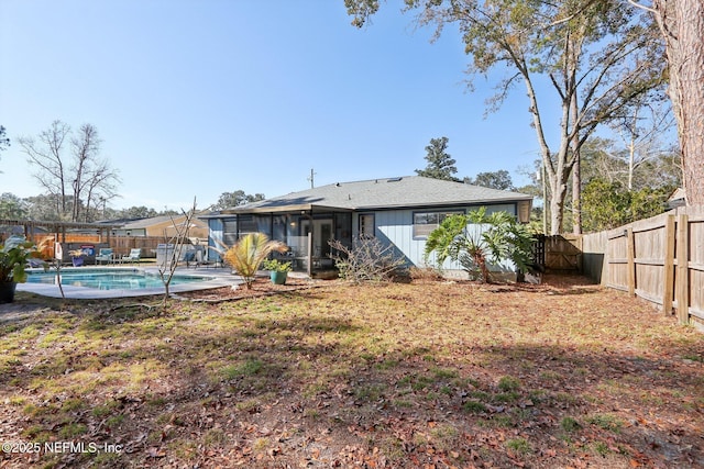 back of house with a fenced in pool and a sunroom