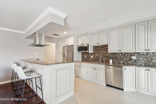 kitchen featuring stone counters, white cabinets, stainless steel appliances, and exhaust hood