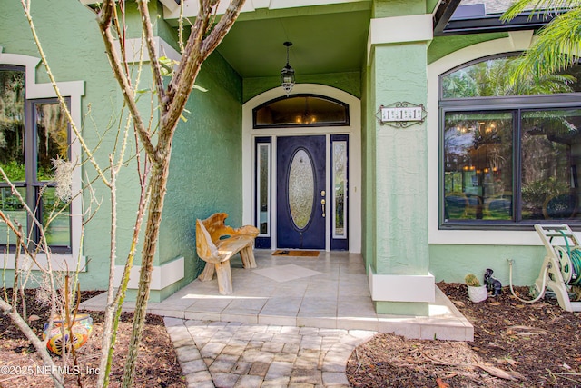 view of exterior entry with stucco siding