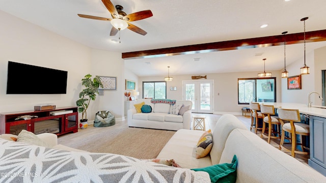 living area featuring vaulted ceiling with beams, french doors, a wealth of natural light, and baseboards