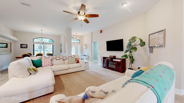 living room featuring baseboards, visible vents, and ceiling fan with notable chandelier