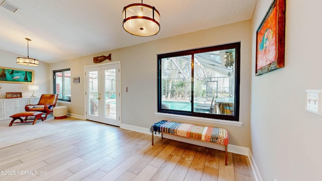 foyer featuring baseboards, visible vents, wood finished floors, and french doors