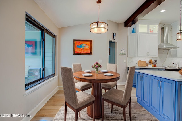 dining area with light wood-type flooring, lofted ceiling with beams, baseboards, and recessed lighting