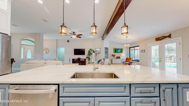 kitchen with appliances with stainless steel finishes, open floor plan, a sink, and french doors