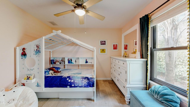 bedroom featuring light wood-style flooring, visible vents, and a ceiling fan