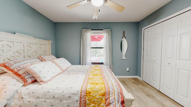 bedroom featuring a ceiling fan, a closet, light wood-style flooring, and baseboards