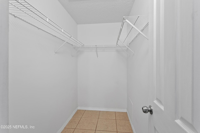 spacious closet featuring light tile patterned floors