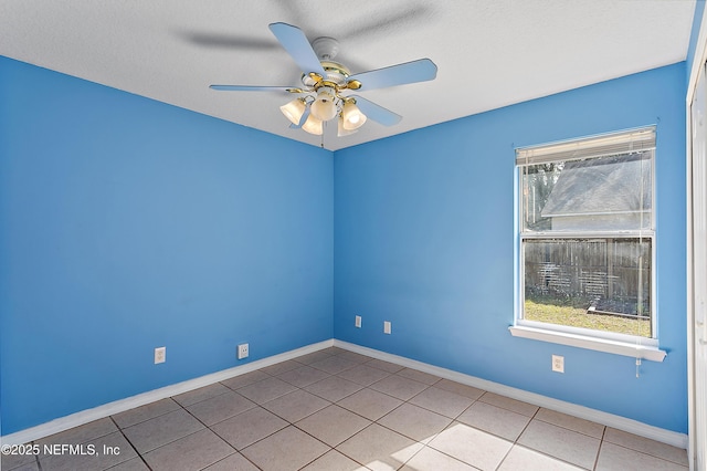 spare room with ceiling fan, plenty of natural light, a textured ceiling, and light tile patterned floors