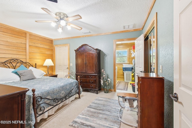 bedroom with ceiling fan, light carpet, and a textured ceiling