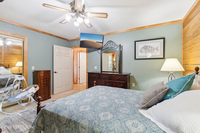 bedroom with wood walls, ornamental molding, light colored carpet, ceiling fan, and a textured ceiling