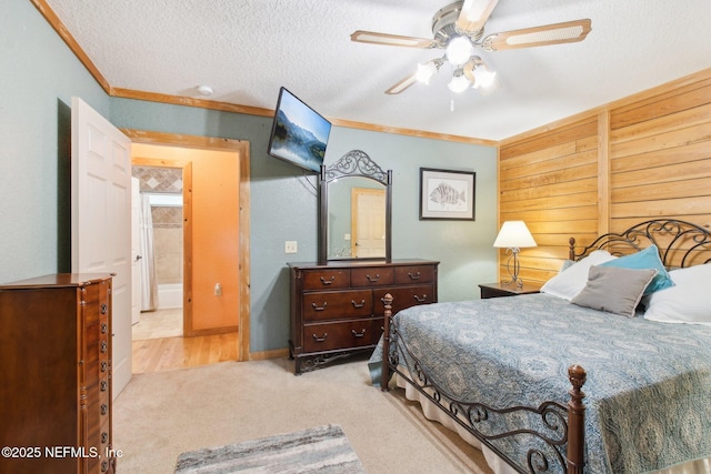 carpeted bedroom with ceiling fan, ornamental molding, and a textured ceiling