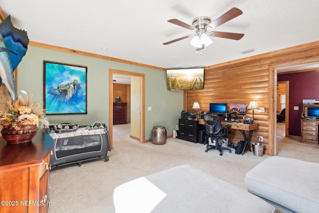 carpeted office space with ceiling fan and rustic walls