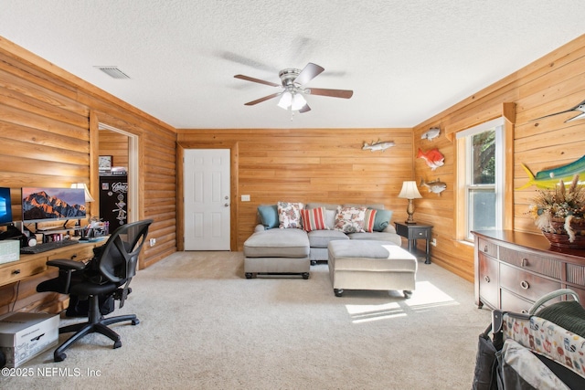 home office with light carpet, ceiling fan, log walls, and a textured ceiling