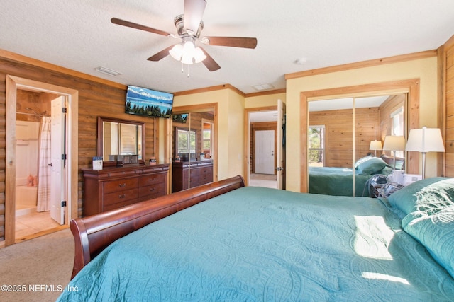 carpeted bedroom featuring ornamental molding, ceiling fan, a textured ceiling, and wooden walls