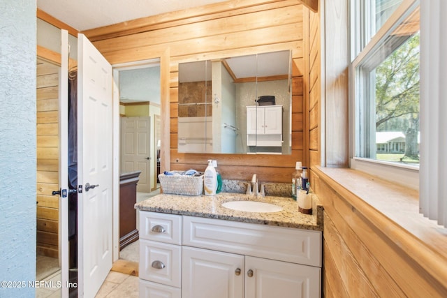 bathroom featuring vanity, wooden walls, and walk in shower