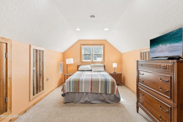 carpeted bedroom with vaulted ceiling and a textured ceiling