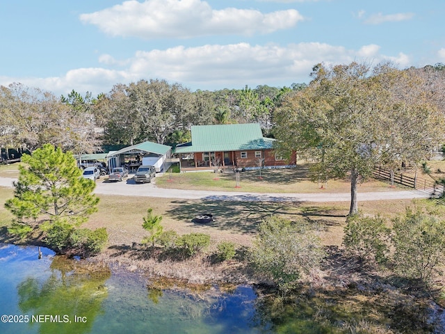 view of yard with a carport and a water view