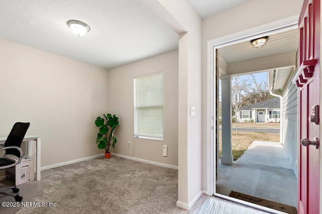 entryway featuring light colored carpet and a textured ceiling