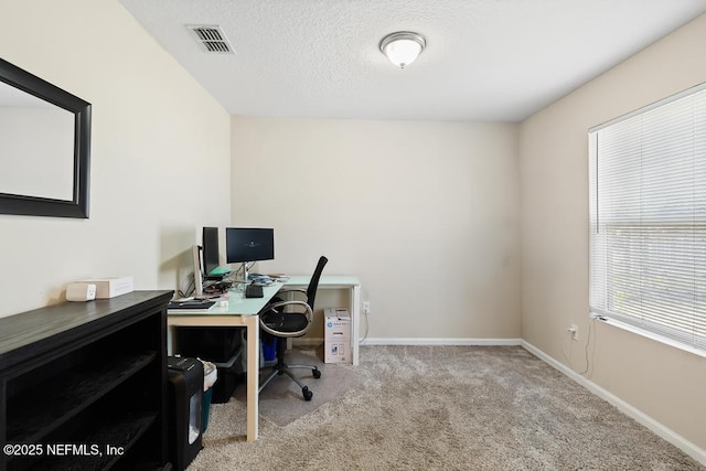 carpeted office space featuring a textured ceiling