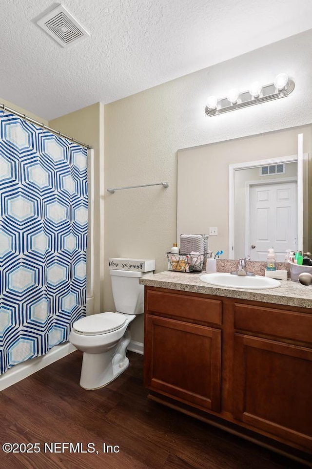 bathroom featuring hardwood / wood-style flooring, vanity, a textured ceiling, a shower with curtain, and toilet