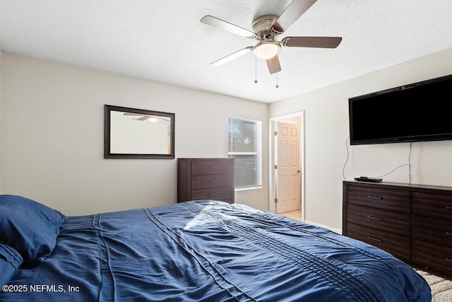 bedroom with ceiling fan and a textured ceiling