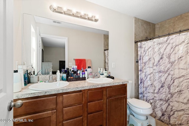 bathroom featuring vanity, toilet, and curtained shower