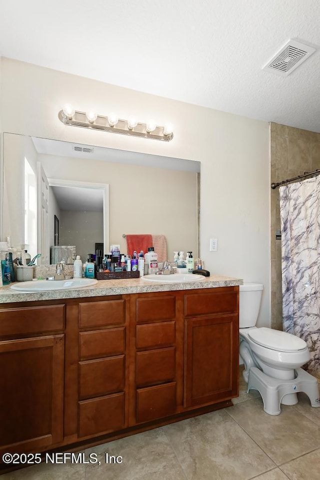 bathroom with vanity, toilet, tile patterned floors, a textured ceiling, and a shower with curtain