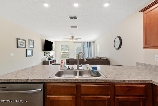 kitchen featuring sink, a textured ceiling, stainless steel dishwasher, kitchen peninsula, and ceiling fan